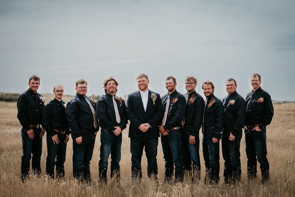 Groom standing with groomsmen in wide open prairie at Buffalo Gap wedding near Belfield
