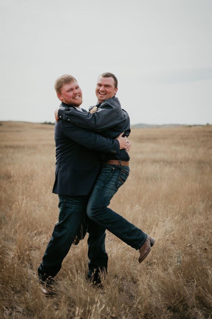 Groom lifting groomsman in the air during fun wedding portraits captured by Belfield wedding photographer