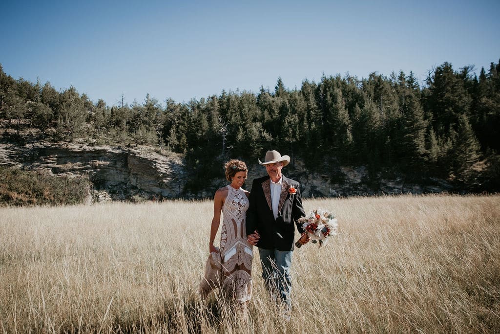 Rustic wedding ceremony arch with macramé backdrop at Eastern Montana ranch wedding.