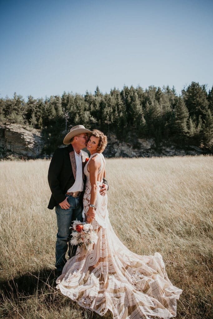 Bride holding bouquet of dried florals and roses during rustic Eastern Montana ranch wedding.