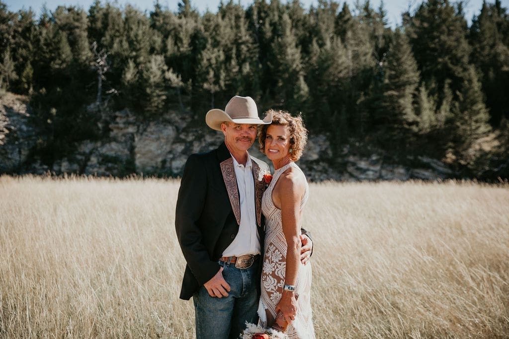 Detail of cowboy hat and embroidered jacket at Montana ranch wedding.