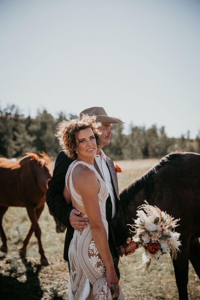 Bride and groom embracing at sunset in Eastern Montana fields.
