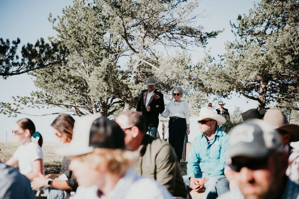 Wedding guests hugging couple after ranch ceremony.