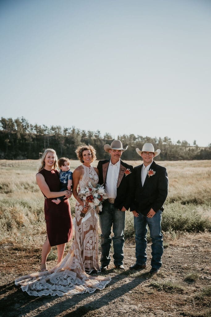 Bride and groom standing together near rustic wooden barn.