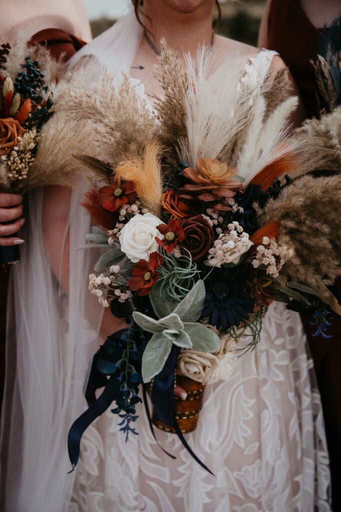 Rustic bridal bouquet with pampas grass, roses, and fall colors at Belfield North Dakota wedding