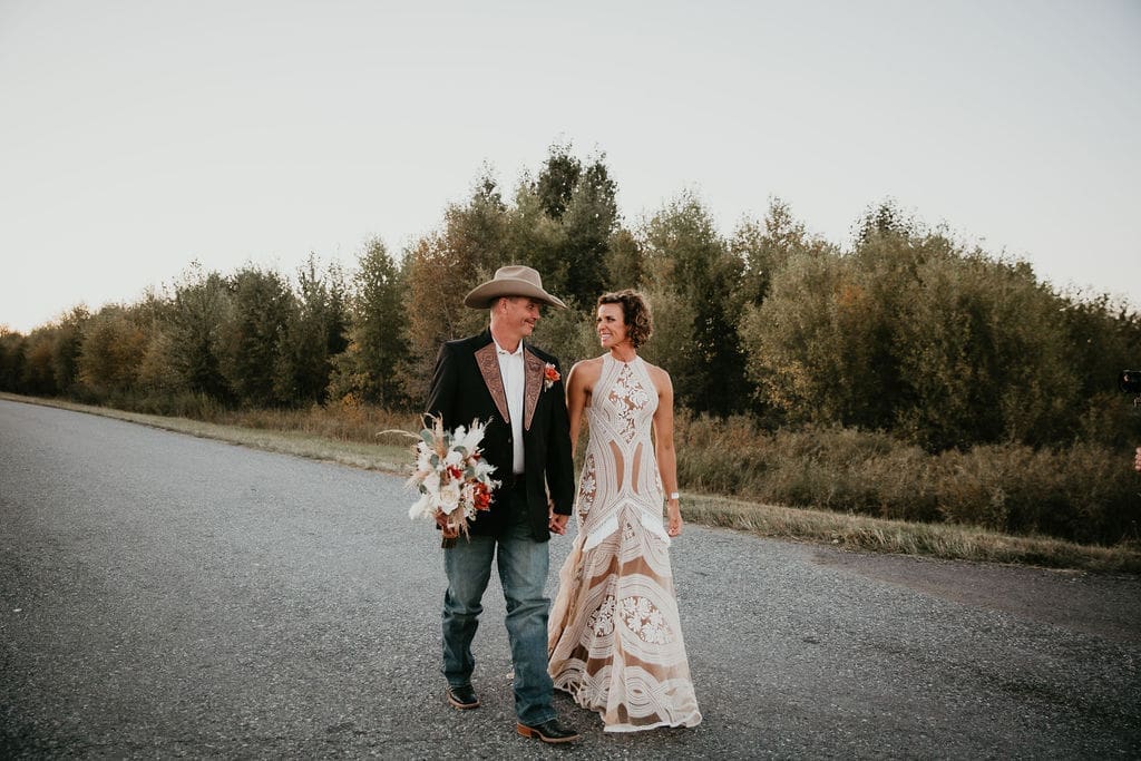 Bride laughing with groom against wide open Montana skies.