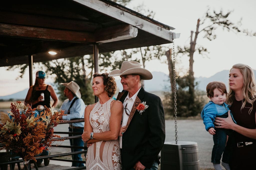 Bride and groom surrounded by friends and family during ranch reception.