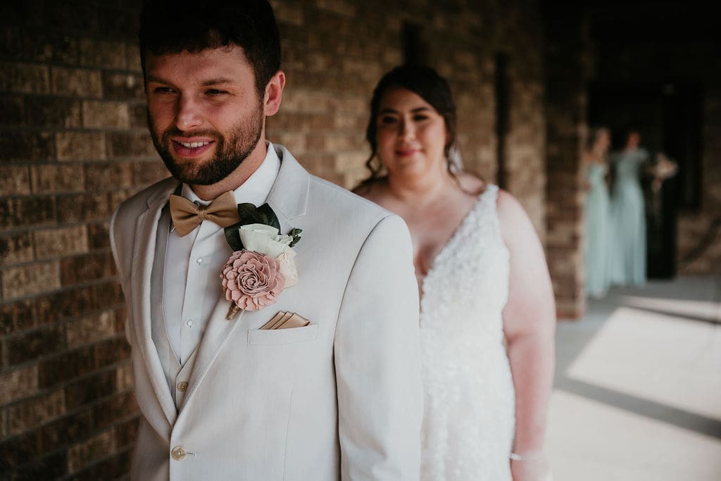 Bride walking up behind groom for first look moment in Billings wedding