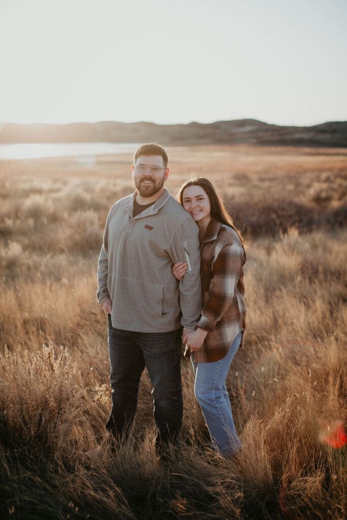 Couple wrapped in flannel laughing together during their fall engagement session.