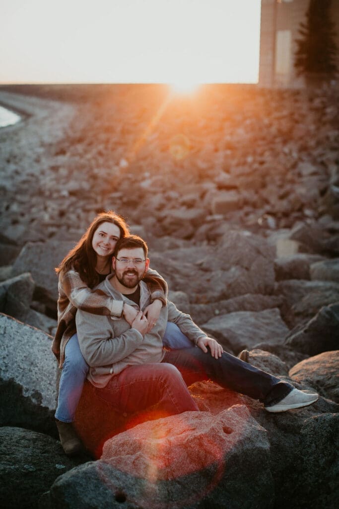 Joyful engagement portrait with sunlight glowing behind the couple’s smiles.
